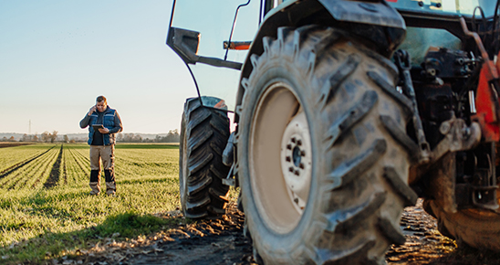 Agriculteur céréalier au téléphone devant son tracteur